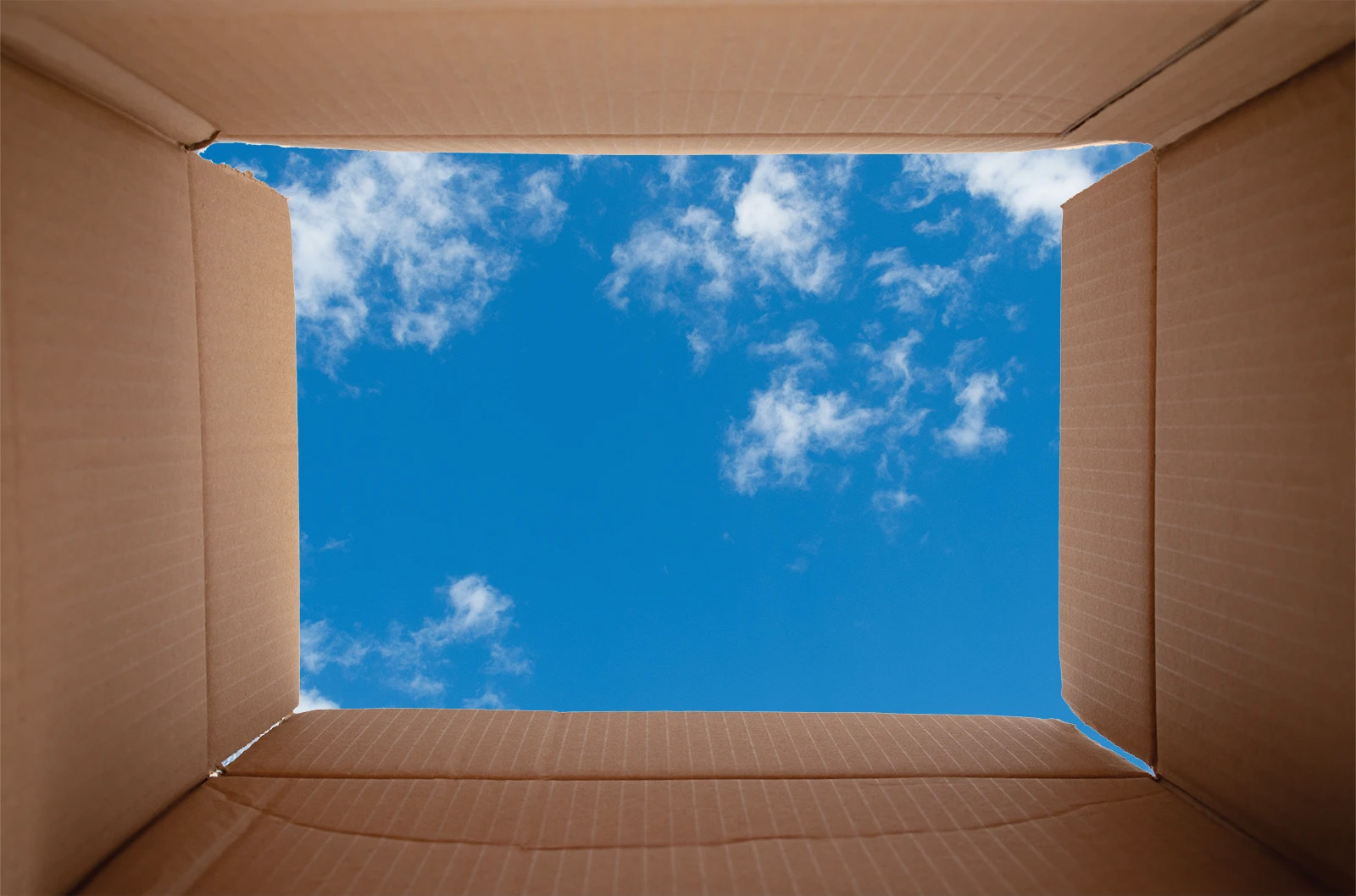 Looking from the inside of a box to a blue sky with clouds